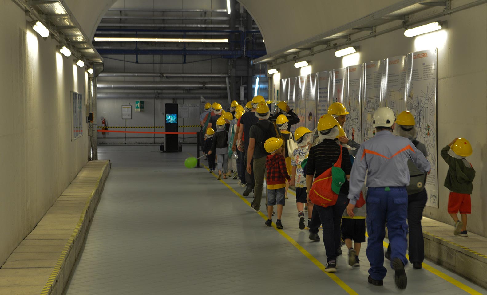 Children with yellow helmets in the hydroelectric plant