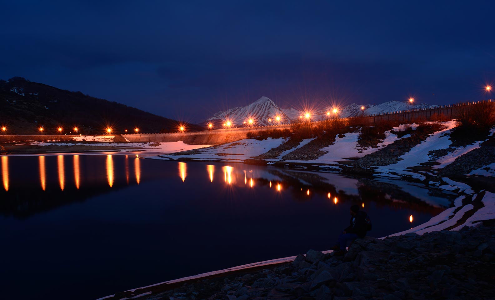 Central hidroeléctrica iluminada durante a noite