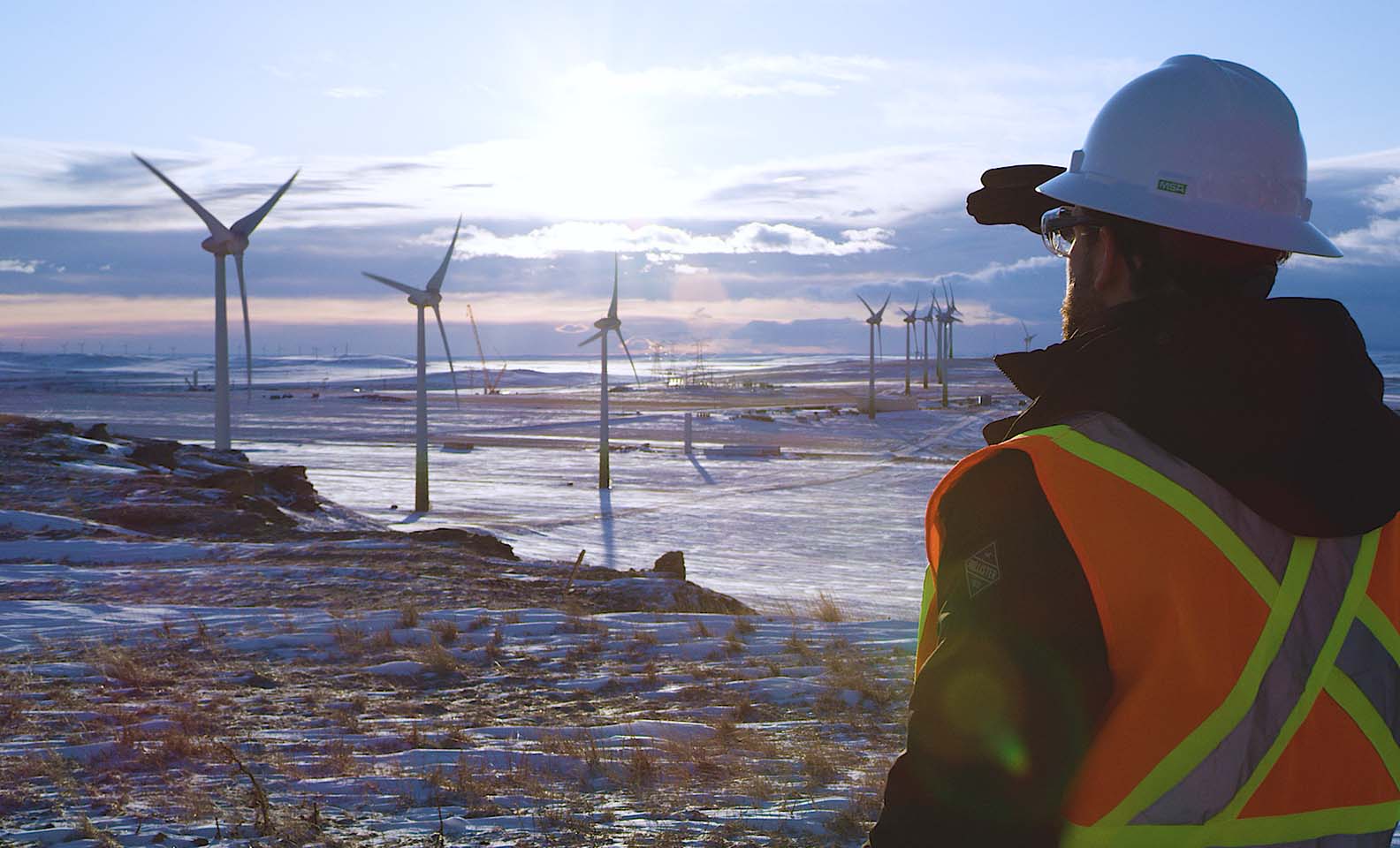 Wind shovels on snowy landscape and EGP operator observing horizon